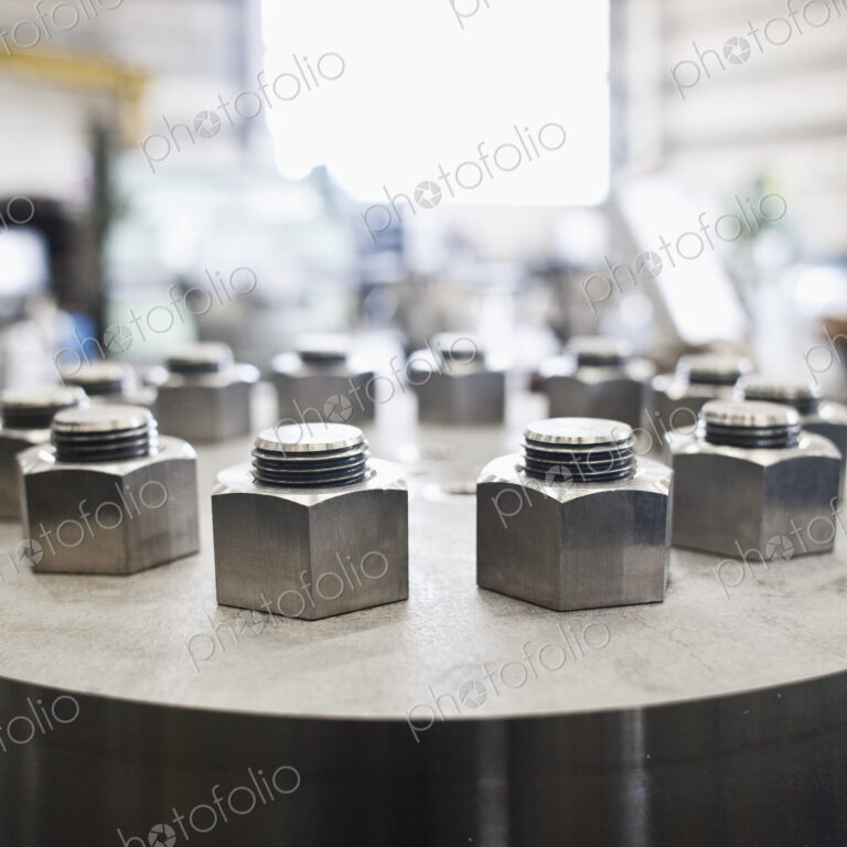 Nuts and bolts on cylinder in workshop.