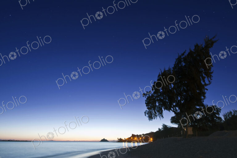 Oahu, Lanikai Beach at dawn, lightening sky on the horizon, beach and palm trees.