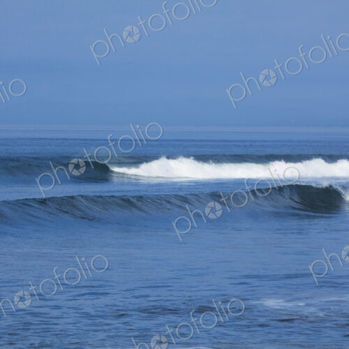 Ocean Waves rolling towards the shore, white water and spray on the breakers.
