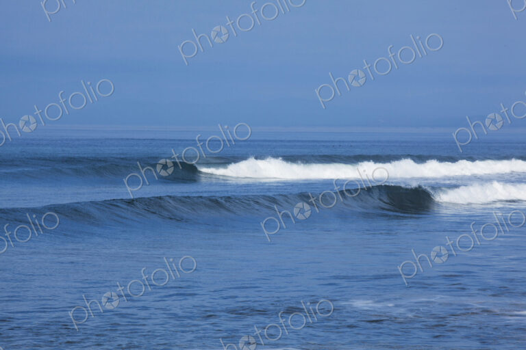 Ocean Waves rolling towards the shore, white water and spray on the breakers.