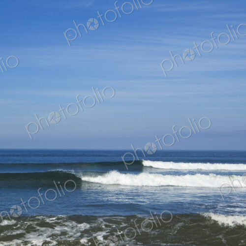 Ocean Waves rolling towards the shore, white water and spray on the breakers.