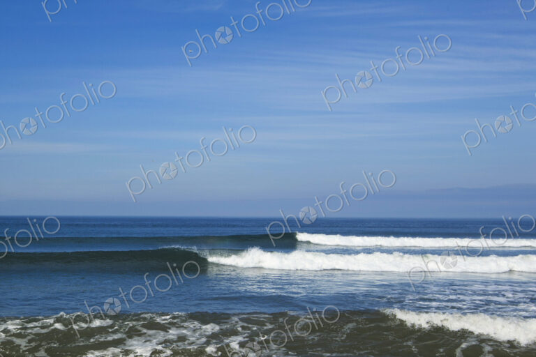 Ocean Waves rolling towards the shore, white water and spray on the breakers.