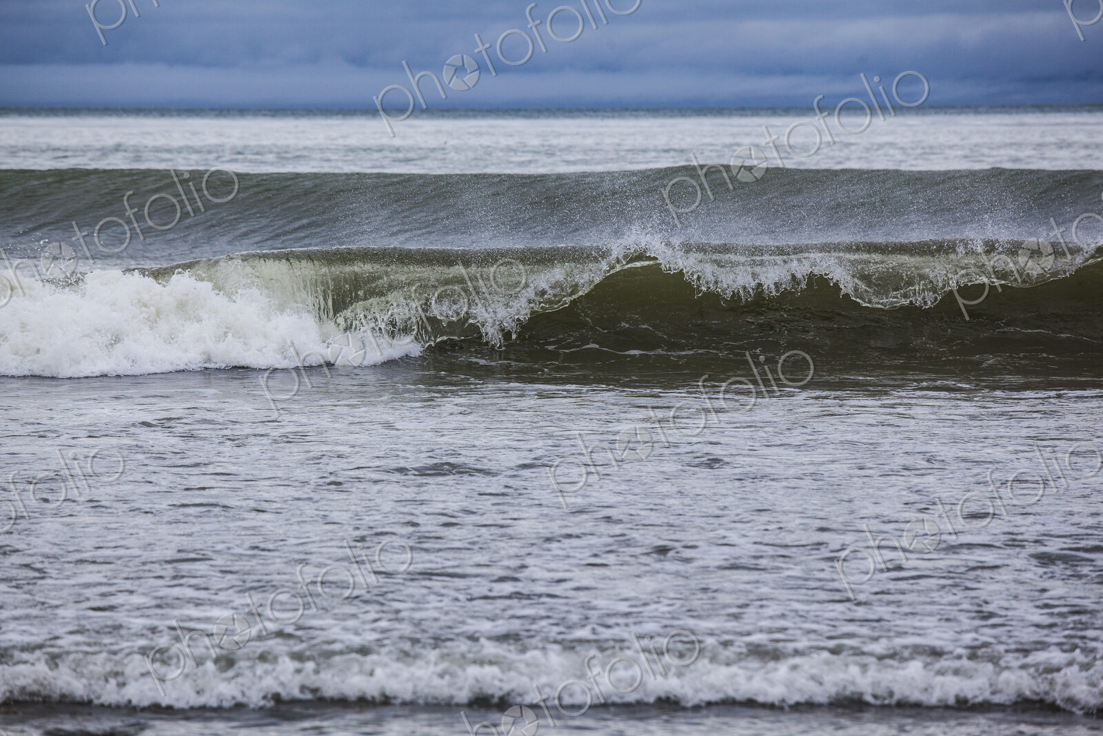 Ocean waves breaking on a beach, view out to the ocean.