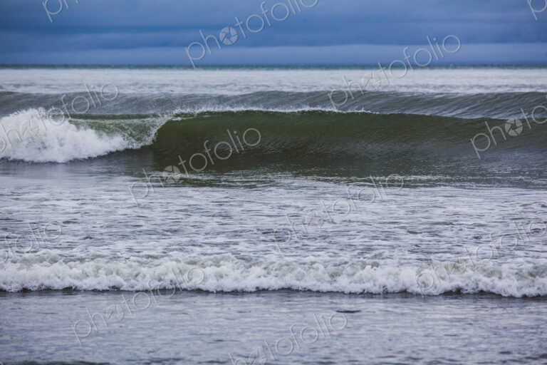 Ocean waves breaking on a beach, view out to the ocean.