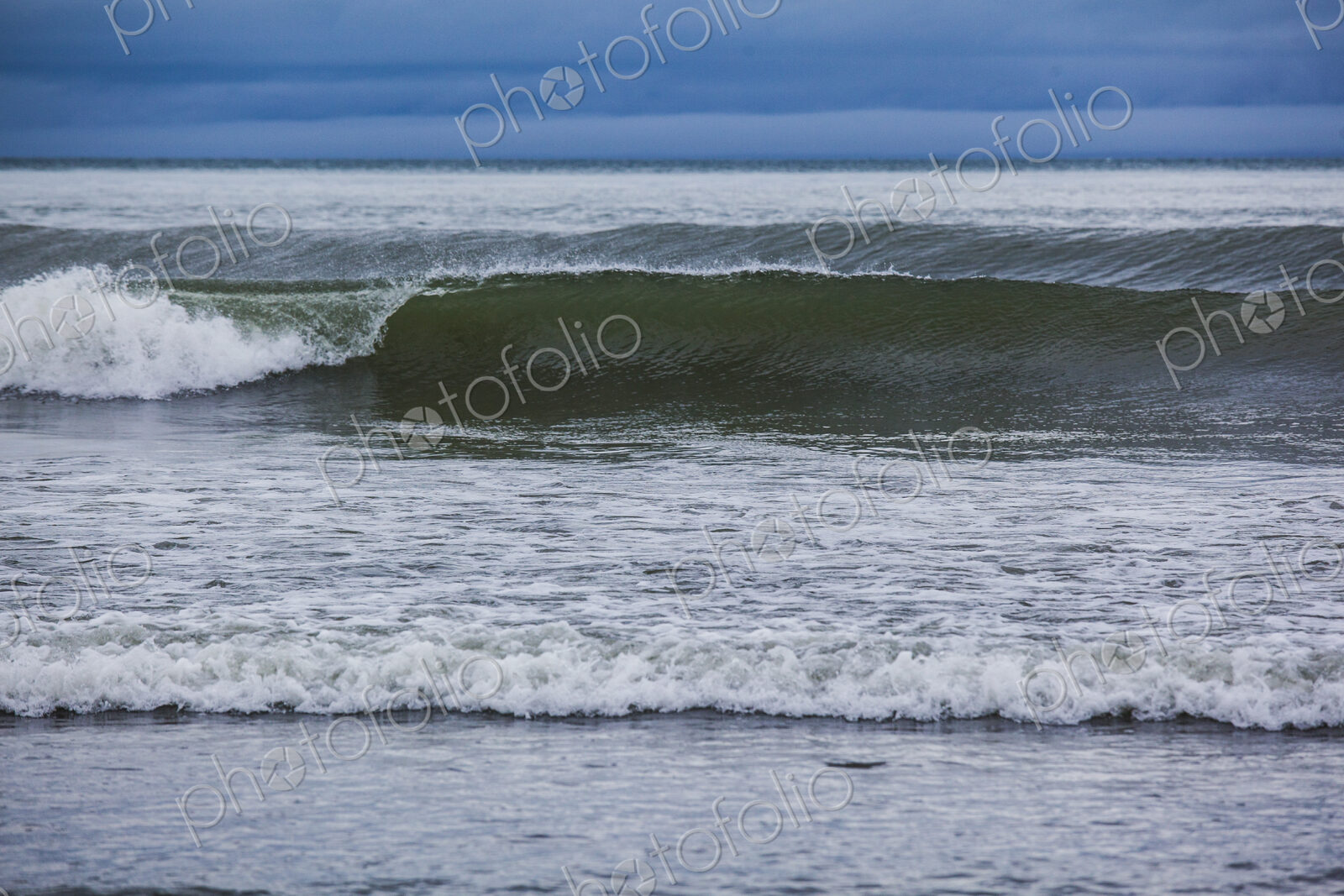 Ocean waves breaking on a beach, view out to the ocean.