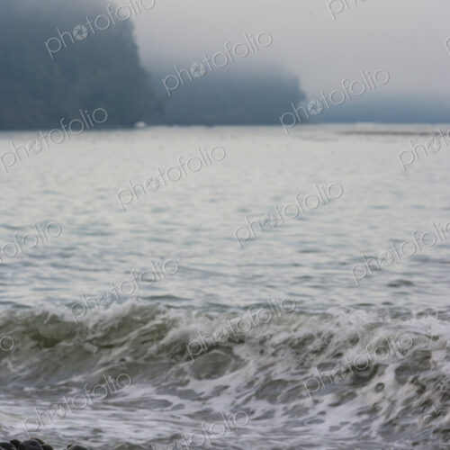 Ocean waves breaking on the beach, smooth beach rocks, Strait of Juan de Fuca