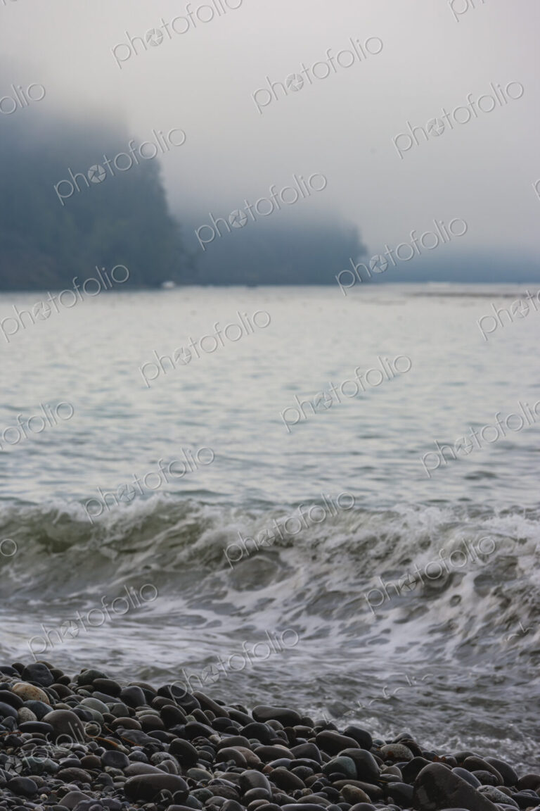 Ocean waves breaking on the beach, smooth beach rocks, Strait of Juan de Fuca