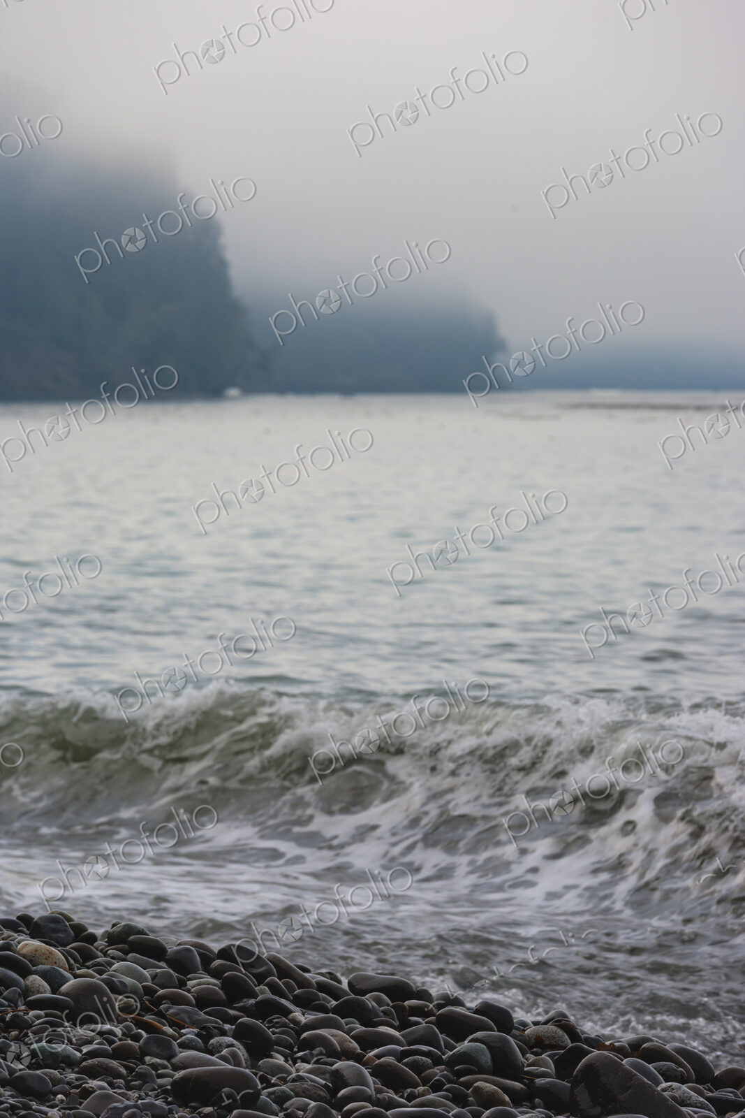Ocean waves breaking on the beach, smooth beach rocks, Strait of Juan de Fuca