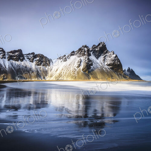 Ocean waves on beach under snowy mountains Ocean waves on beach under snowy mountains