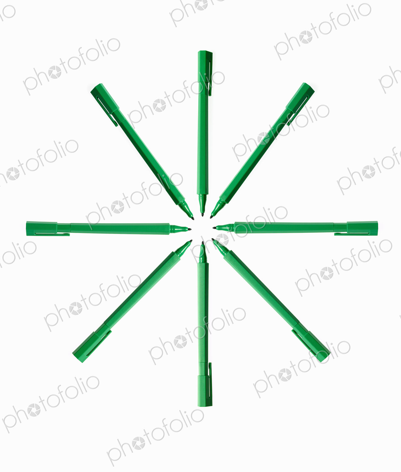 Office supplies. Green coloured pens, felt nibs and pen top cases, arranged in a star…