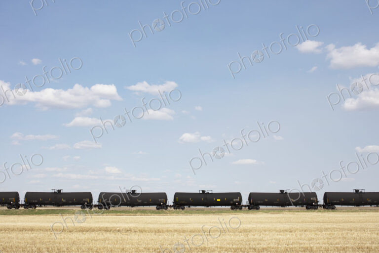 Oil train cars and fallow farmland, near Swift Current, Saskatchewan, Canada.