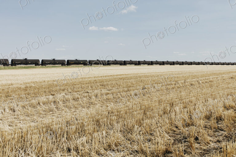 Oil train cars and fallow farmland, near Swift Current, Saskatchewan, Canada.