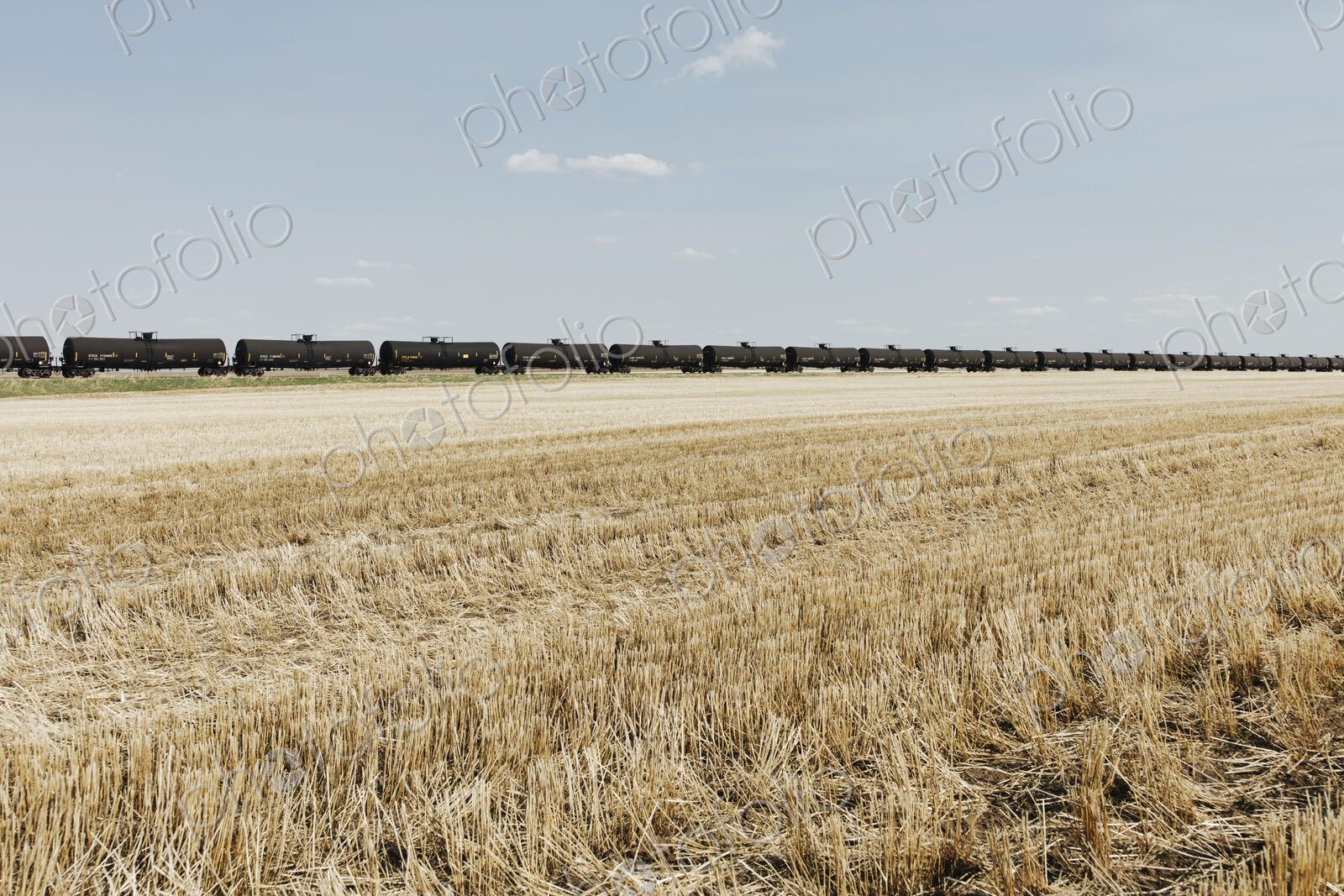Oil train cars and fallow farmland, near Swift Current, Saskatchewan, Canada.