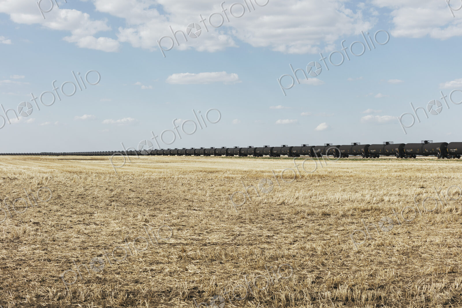 Oil train cars and fallow farmland, near Swift Current, Saskatchewan, Canada.