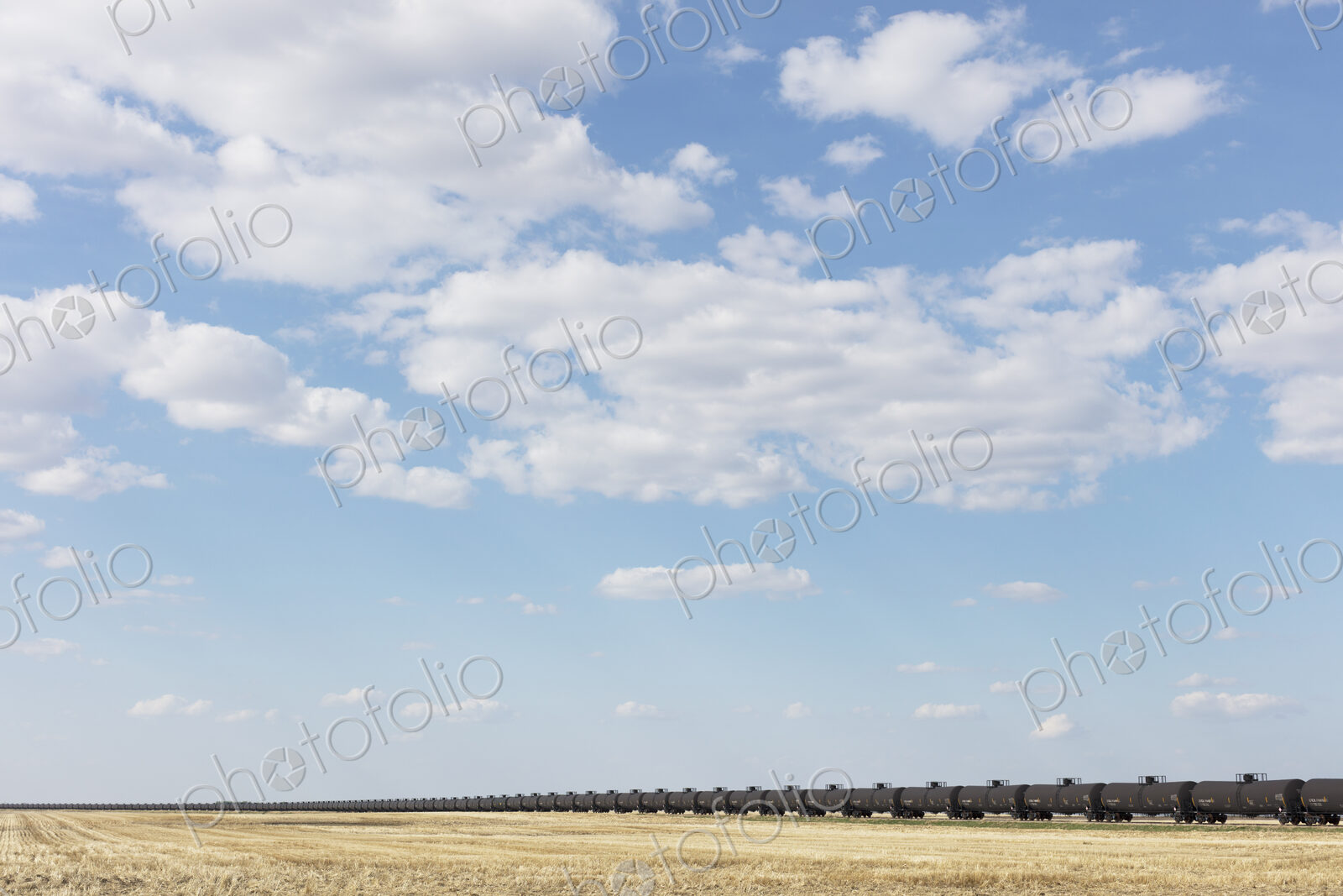 Oil train cars and fallow farmland, near Swift Current, Saskatchewan, Canada.