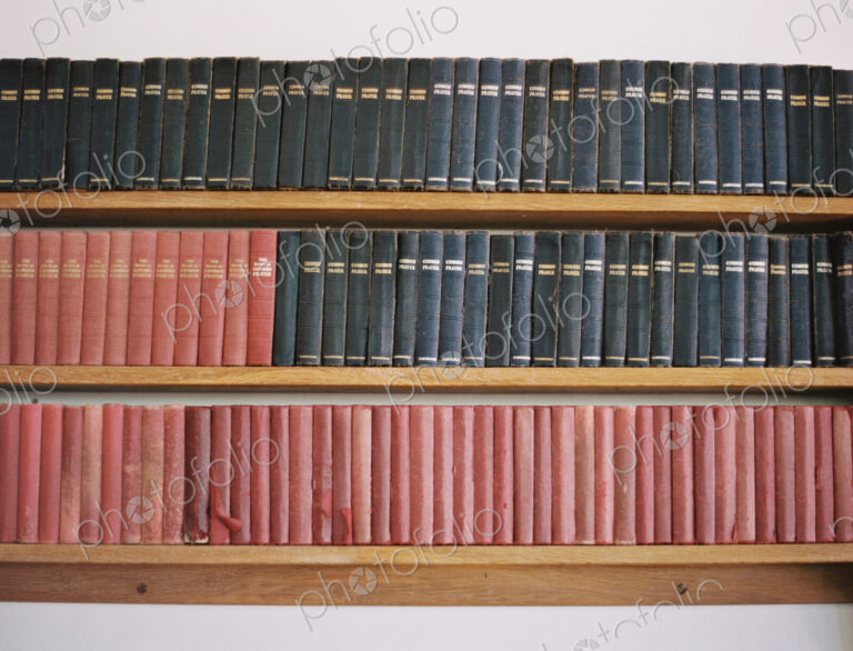 Old books on a shelf. Traditional church prayer books. Worn covers.