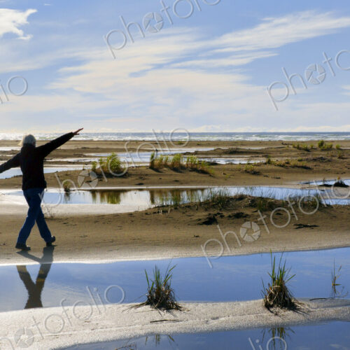 Older woman walking in marshy rural field Older woman walking in marshy rural field