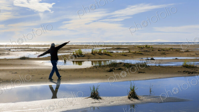 Older woman walking in marshy rural field