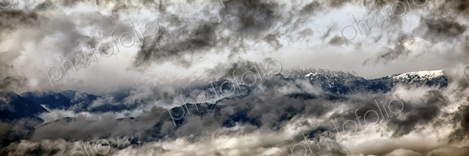 Olympic mountains seen through heavy cloud layer.