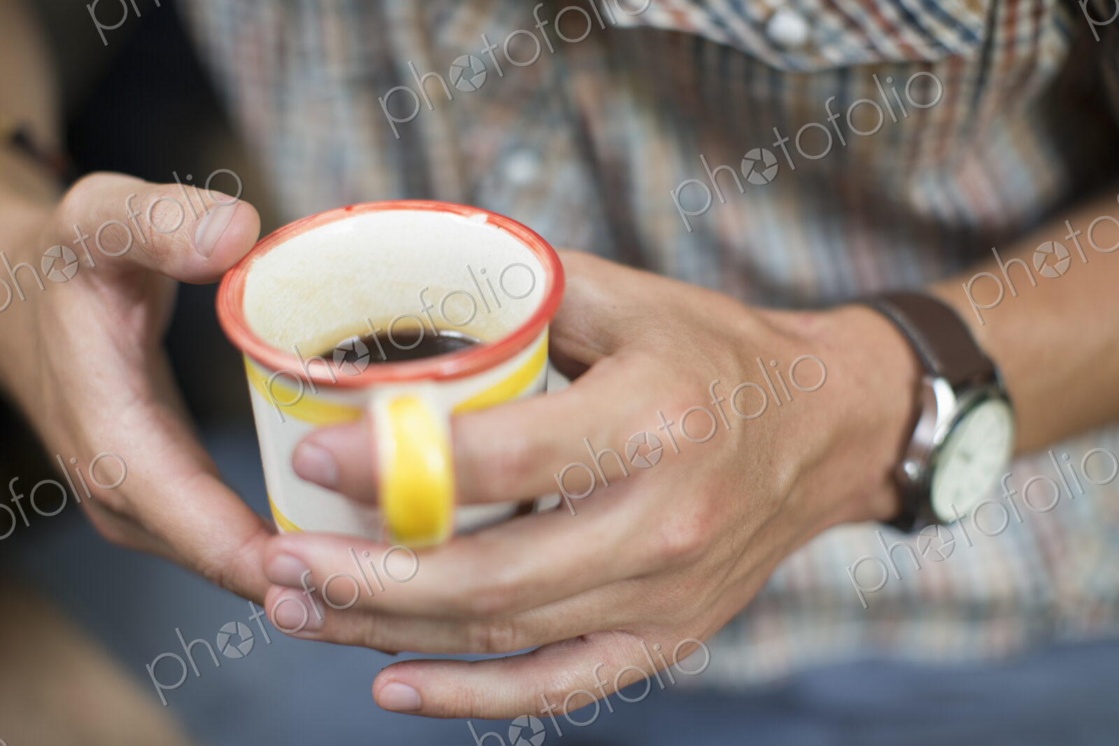 One person at a picnic table outdoors, holding a china mug.