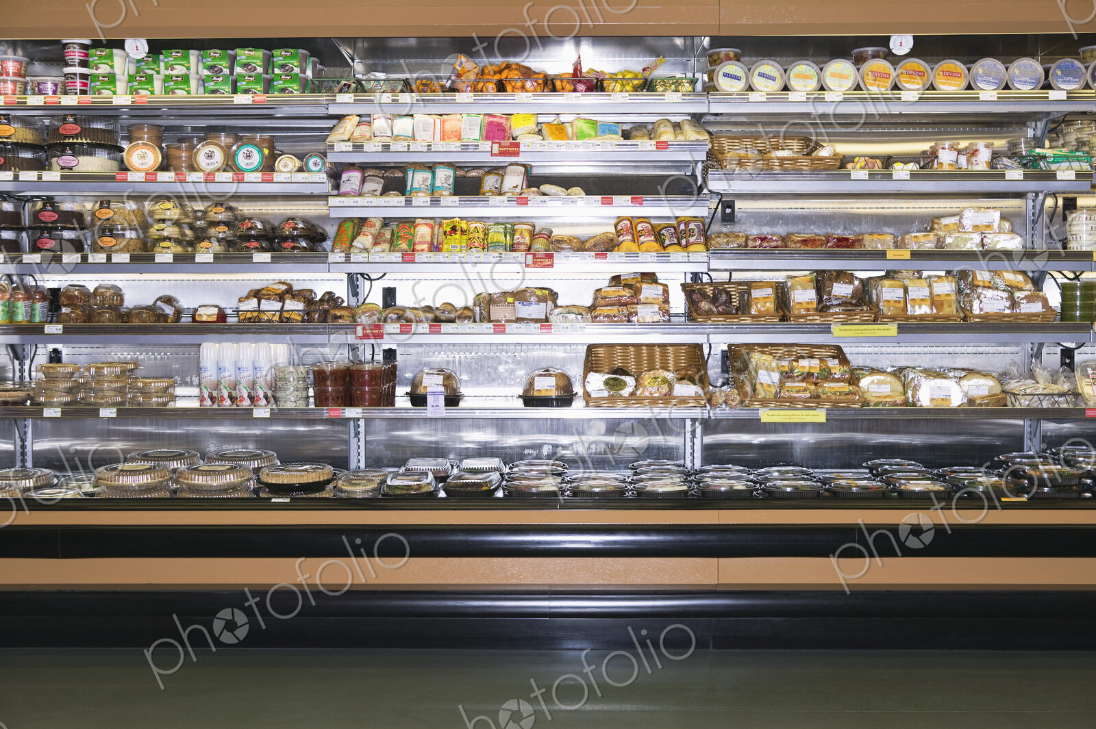 Open refridgerator stocked with food in supermarket.
