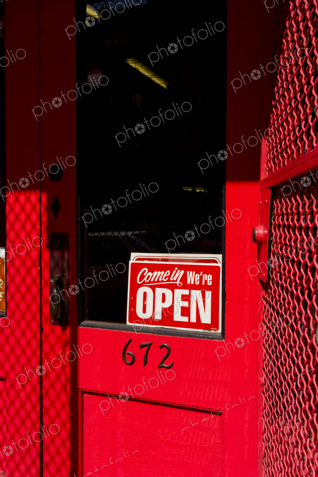 Open sign on red wooden door, a business or shop.