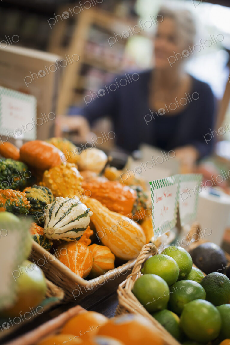 Organic Farmer at Work. A farm stand, with a display of goudes and squash of different…