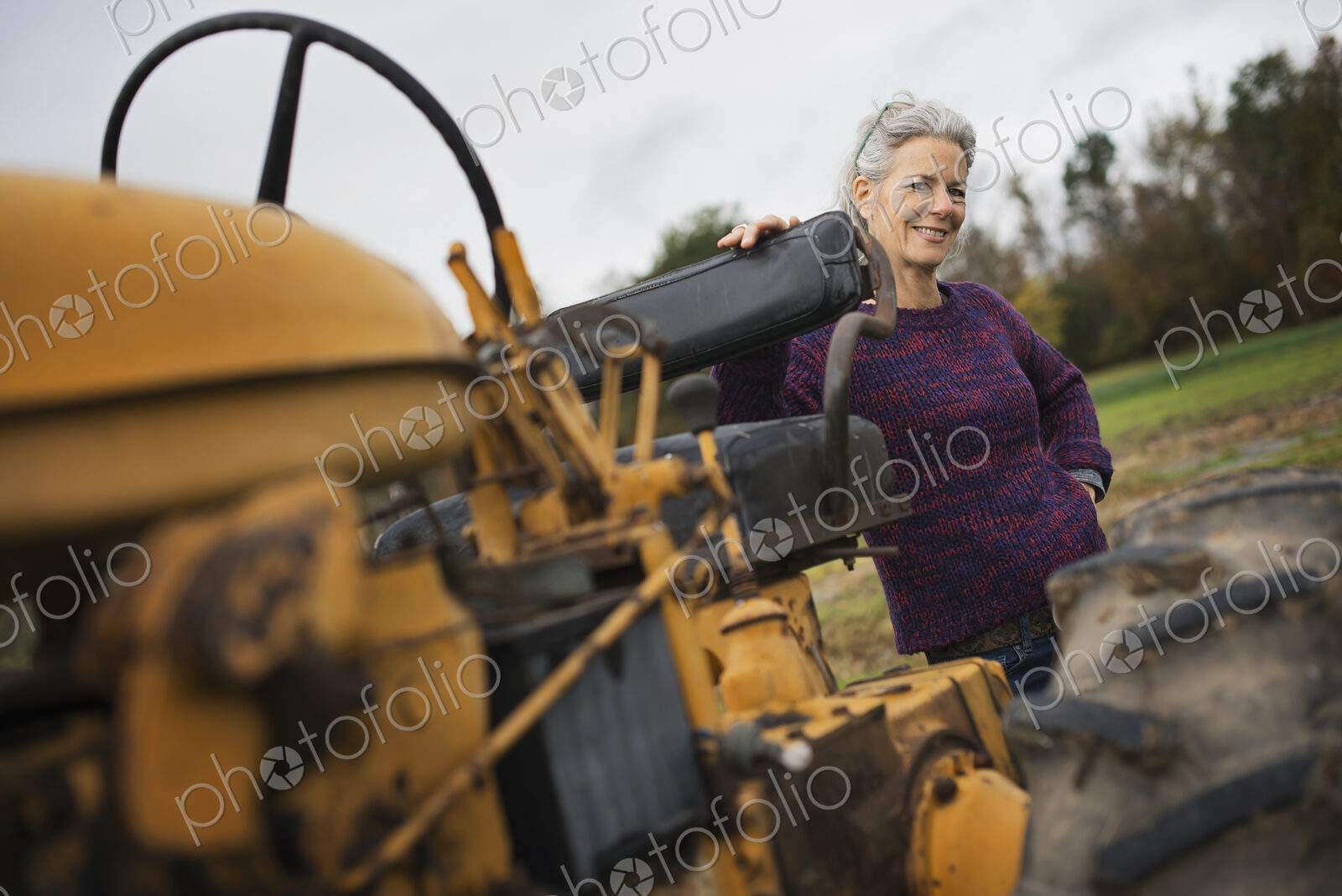 Organic Farmer at Work. A woman by a tractor.
