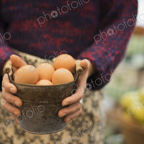 Organic Farmer at Work. A woman carrying a container of eggs. Organic Farmer at Work. A woman carrying a container of eggs.