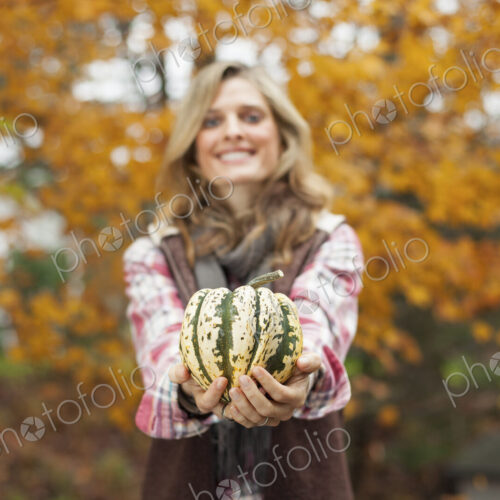 Organic farm. A woman holding a large striped squash vegetable. Organic farm. A woman holding a large striped squash vegetable.