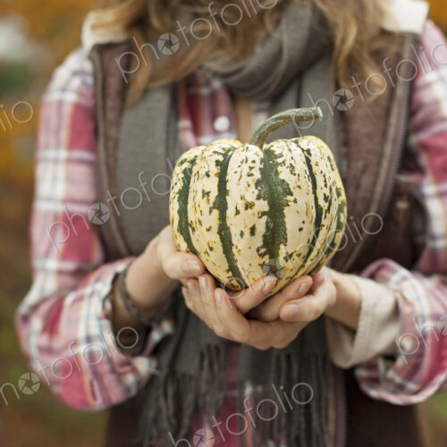 Organic farm. A woman holding a large striped squash vegetable. Organic farm. A woman holding a large striped squash vegetable.