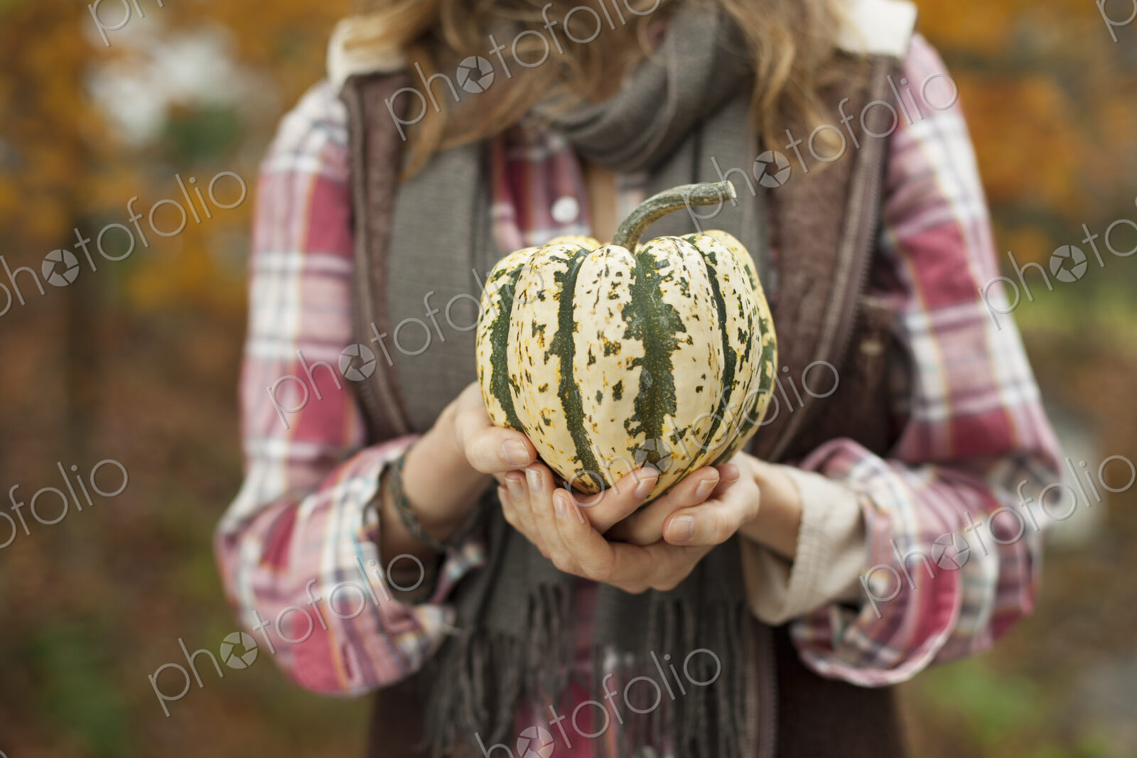 Organic farm. A woman holding a large striped squash vegetable.