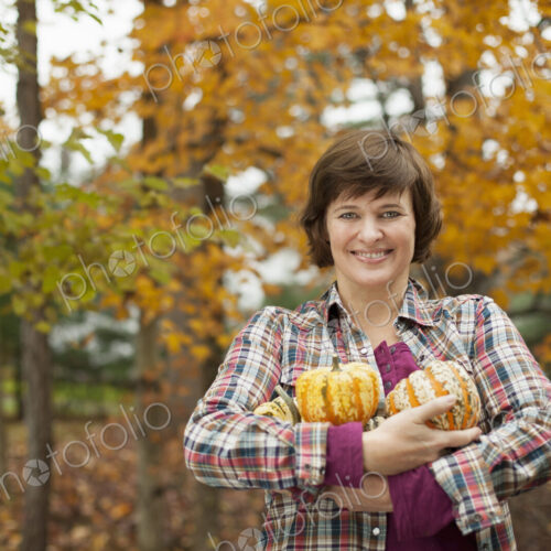 Organic farm. A woman holding an armful of large squash vegetables. Organic farm. A woman holding an armful of large squash vegetables.