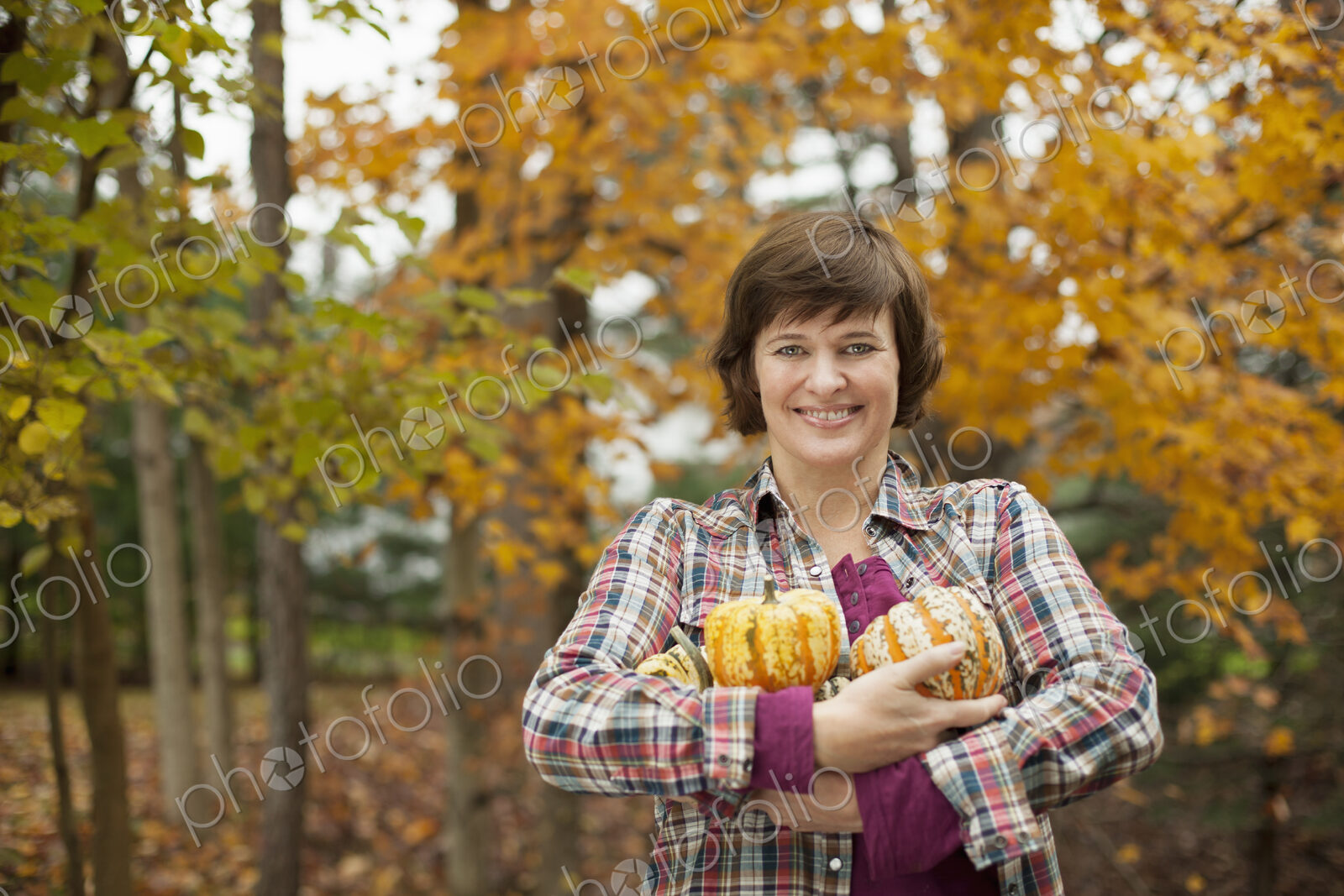 Organic farm. A woman holding an armful of large squash vegetables.