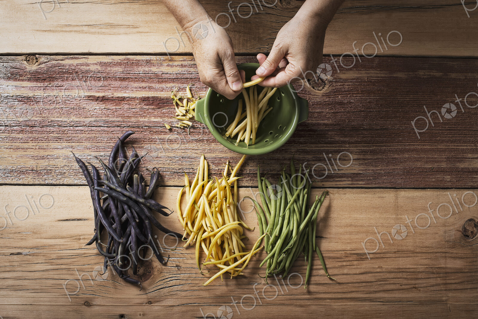 Organic green, yellow and black haricot beans, fresh vegetables being topped and…