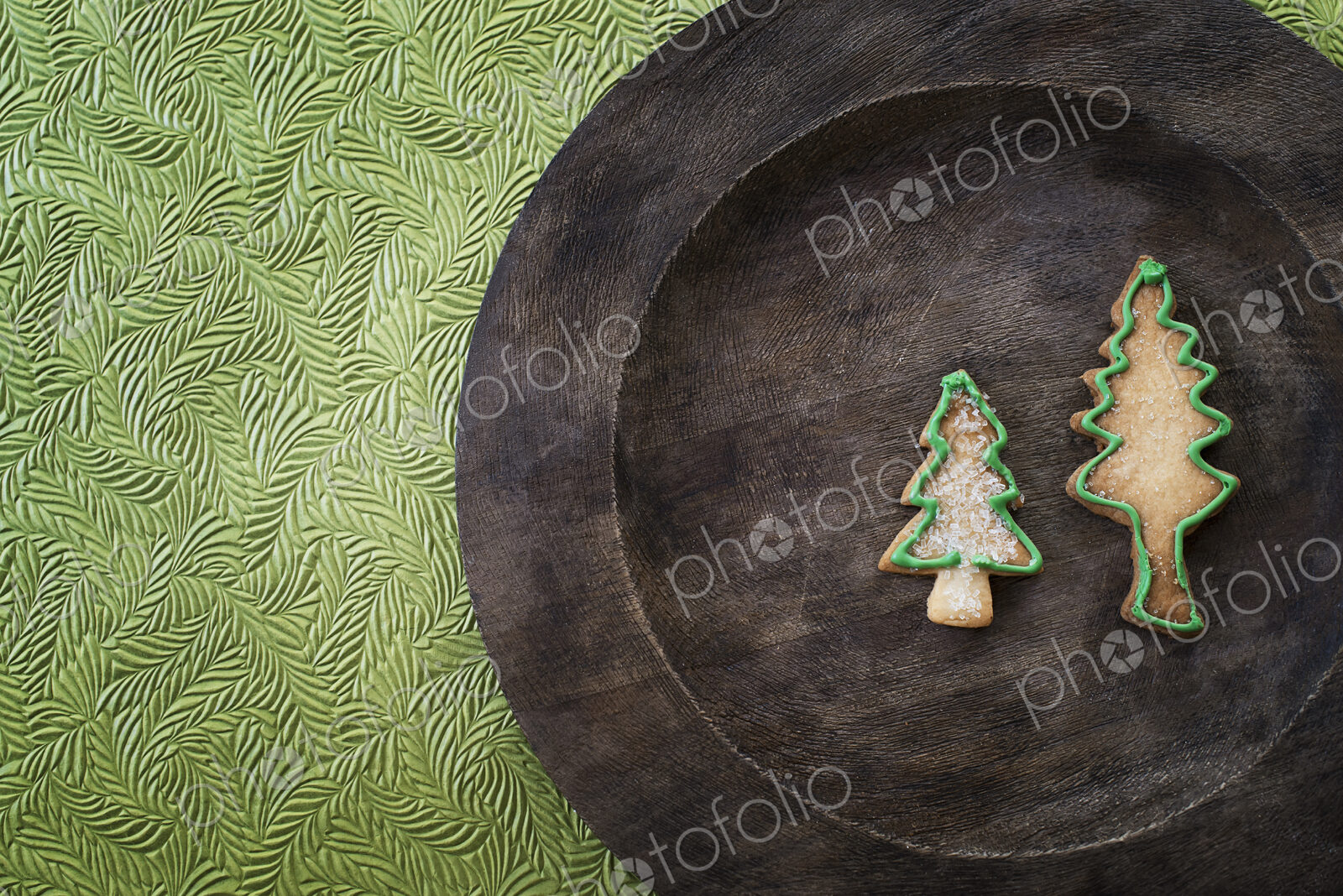 Organic homemade Christmas cookies in the shape of Christmas trees on a round wooden…