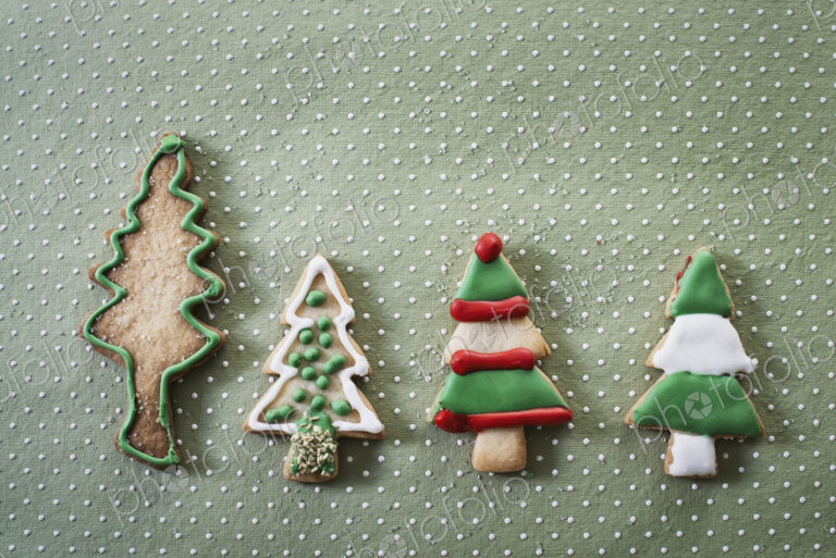 Organic homemade Christmas cookies shaped like Christmas trees, iced with green, red…