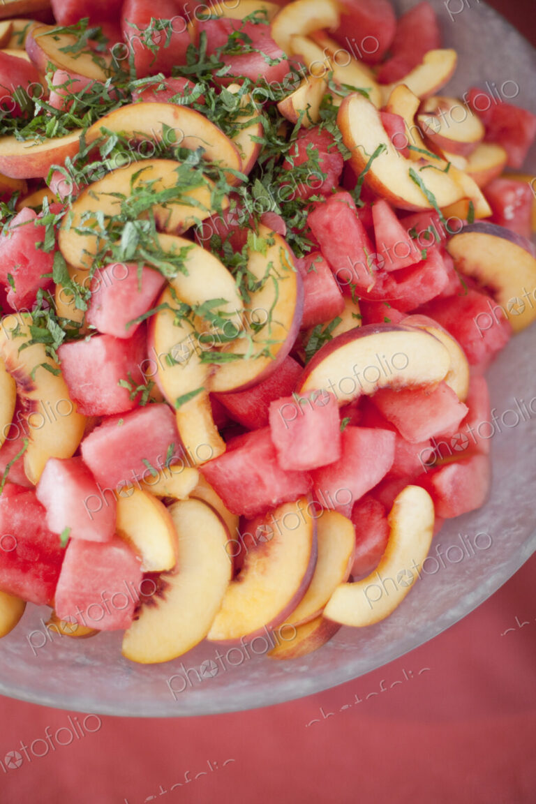Organic prepared farmstand party food. Summer fruit salad of watermelon, peaches and mint.