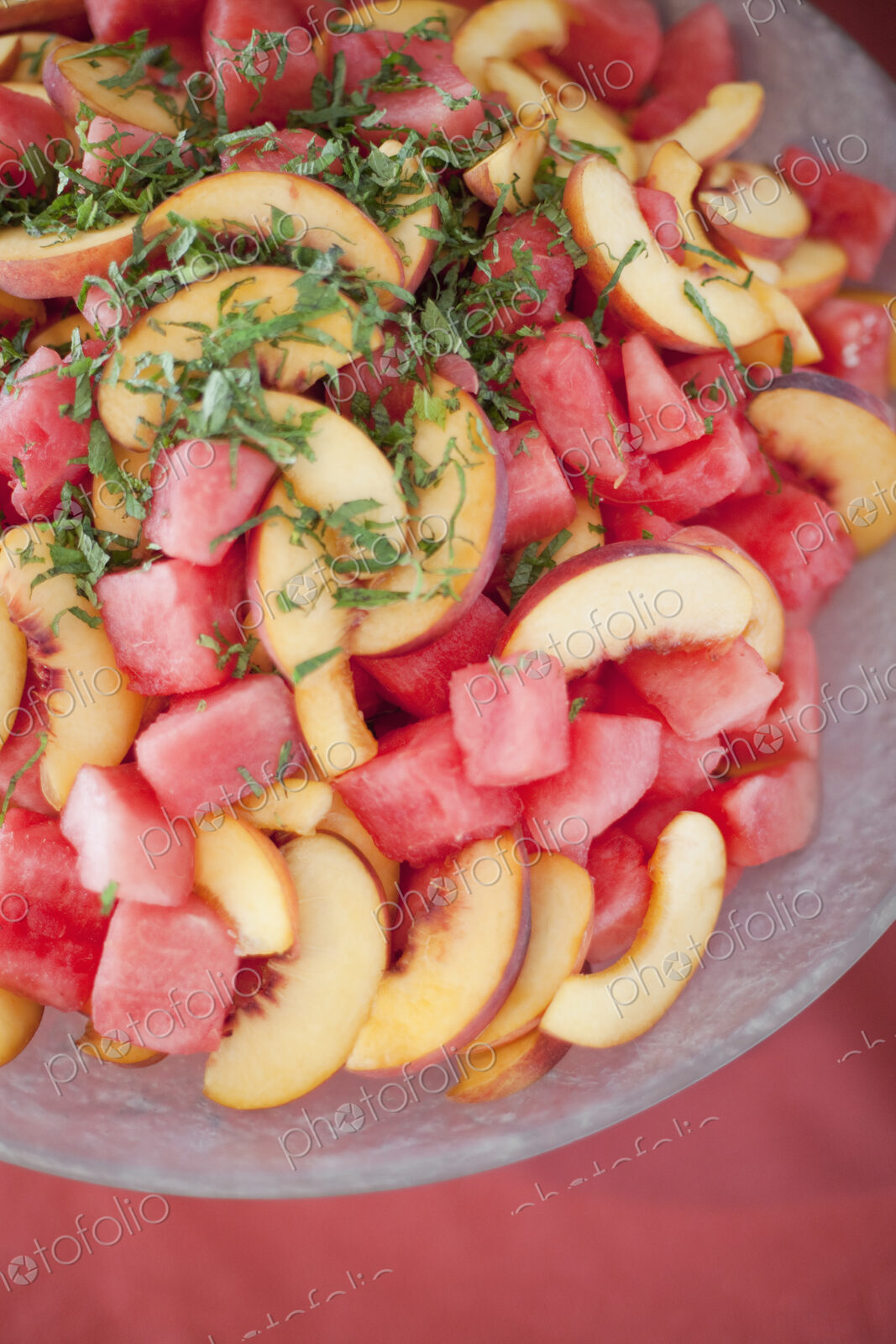 Organic prepared farmstand party food. Summer fruit salad of watermelon, peaches and mint.