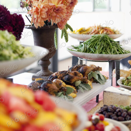Organic prepared salads, vegetables and fruit on dishes, laid out for a party. A laden…