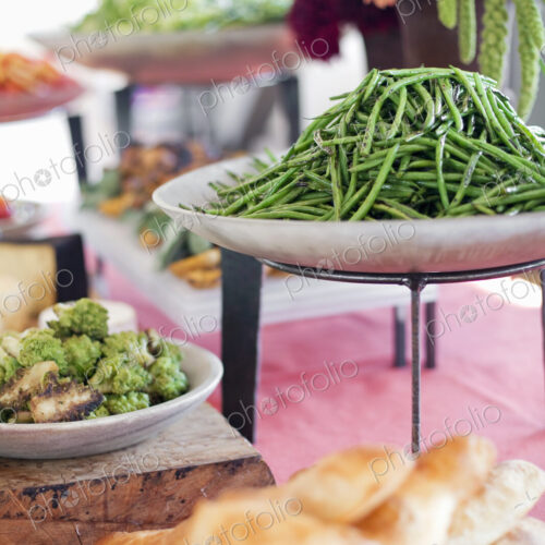 Organic prepared salads, vegetables and fruit on dishes, laid out for a party. A laden…