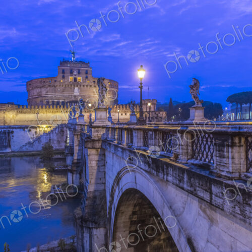 Ornate bridge and Ponte Sant'Angelo illuminated at night, Rome, Italy