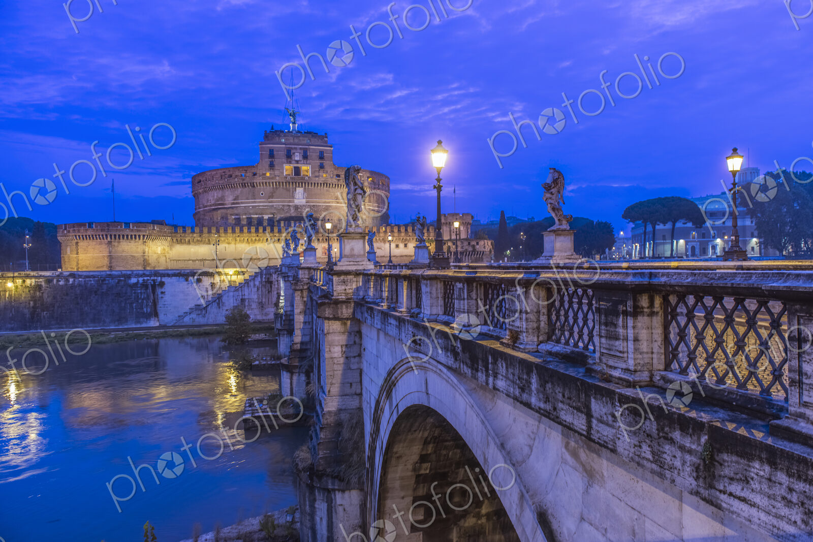 Ornate bridge and Ponte Sant’Angelo illuminated at night, Rome, Italy