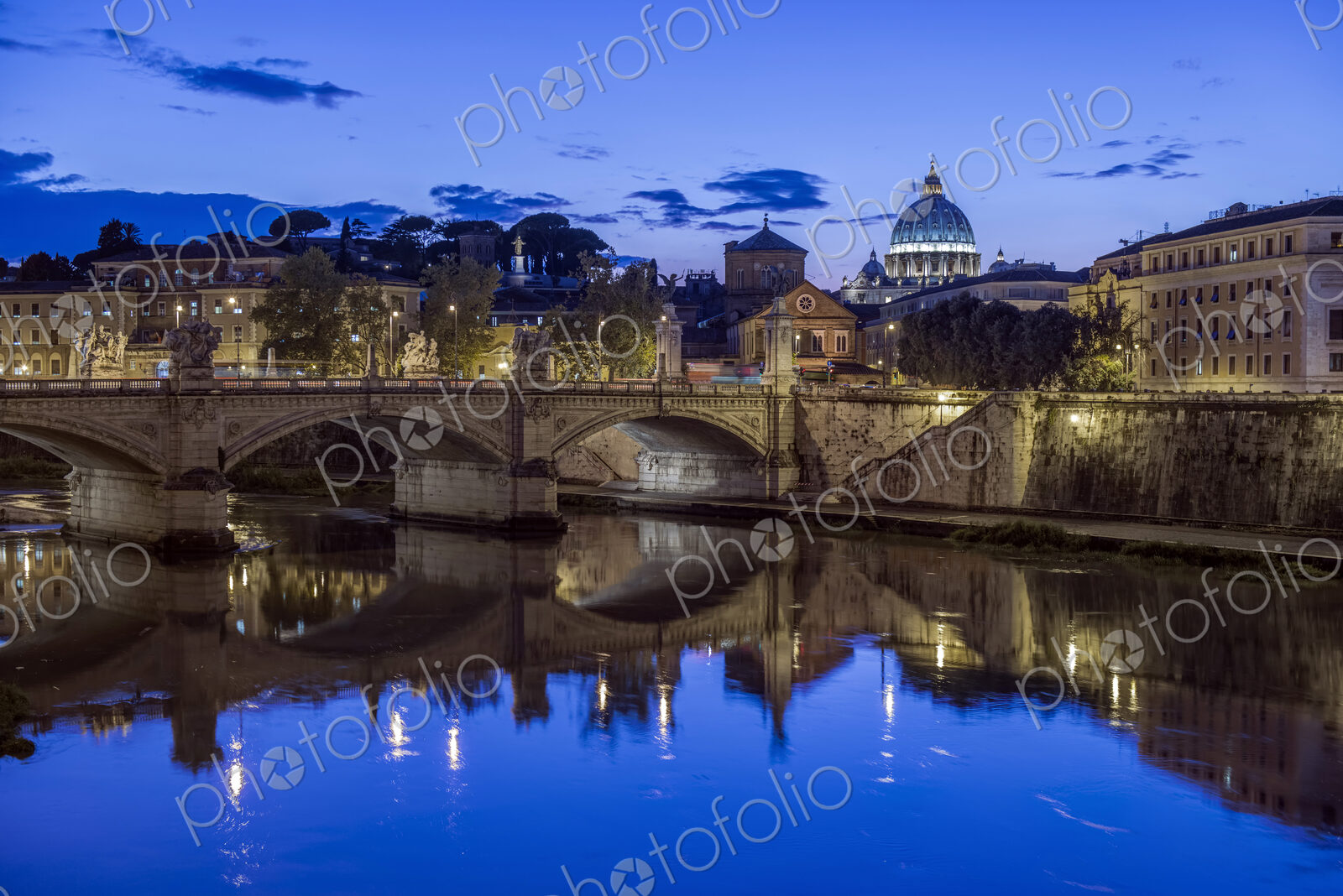 Ornate buildings and bridge illuminated at night, Rome, Italy
