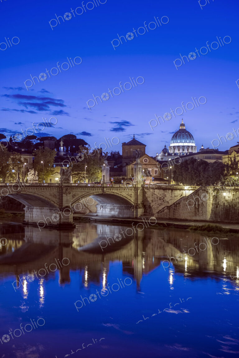 Ornate buildings and bridge illuminated at night, Rome, Italy
