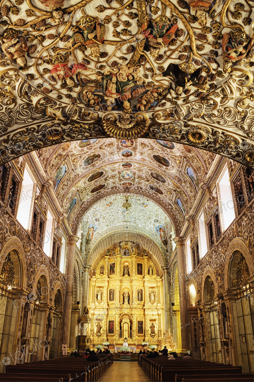 Ornate interior and decorated ceiling of a church.