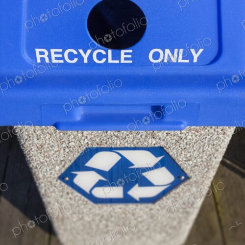 Outdoor recycling bin with blue lid labeled for aluminum and plastic, featuring a…