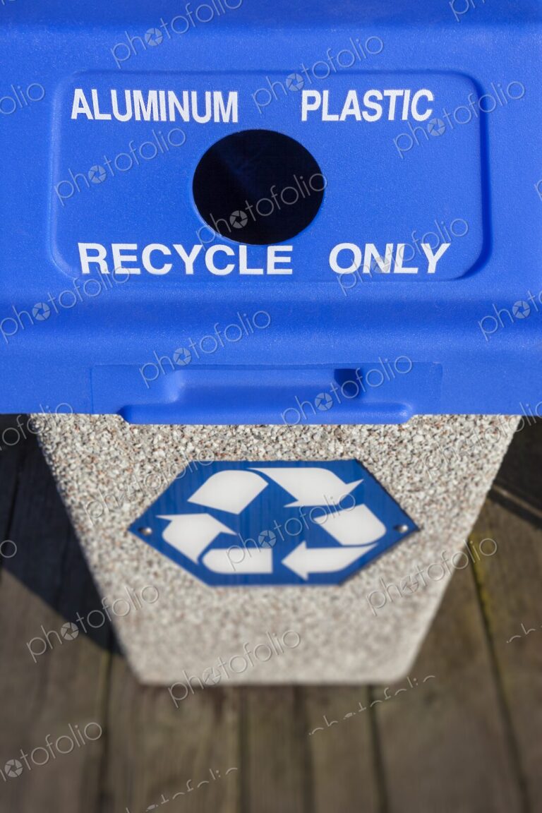Outdoor recycling bin with blue lid labeled for aluminum and plastic, featuring a…