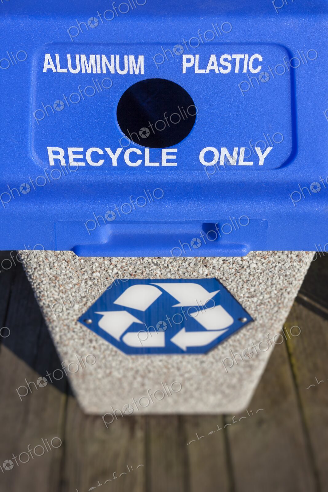 Outdoor recycling bin with blue lid labeled for aluminum and plastic, featuring a…
