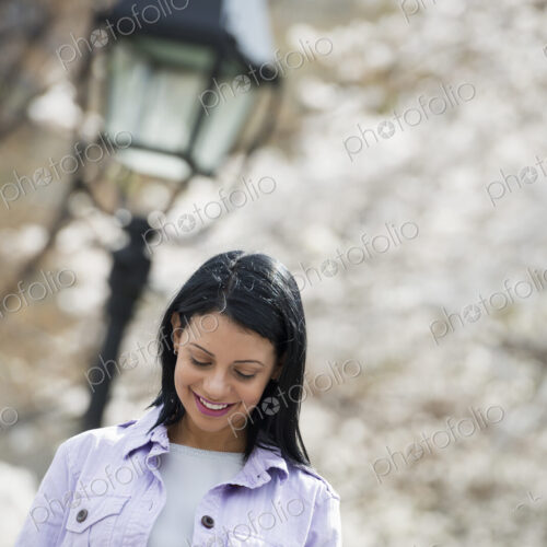 Outdoors in the city in spring time. New York City park. White blossom on the trees. A…